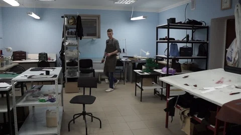 Tanner manually stitches a leather product. Man sews a brown leather wallet Stock Footage 104927331