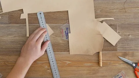 Tanner measures a small piece of leather and gently cuts it Video stock 81410934