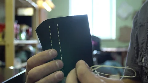 The tanner stitches the leather workpieces. Hand made close-up. 4k. Stock Footage 77878934