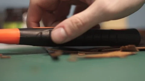 The tanner takes a rubber mallet with a red handle from the table. On the table Stock Footage 104927665