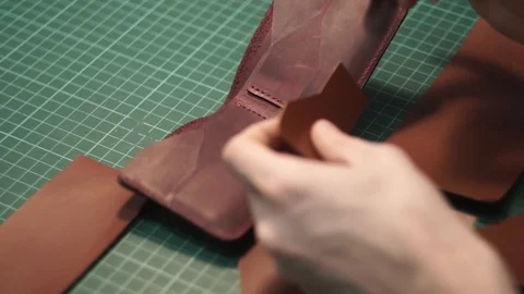 The tanner, using a cotton swab, paints the ends of the leather blank. Brown Stock Footage 104927072