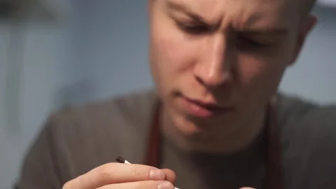 The tanner, using a cotton swab, paints the ends of the leather blank. Brown Stock Footage 104927079