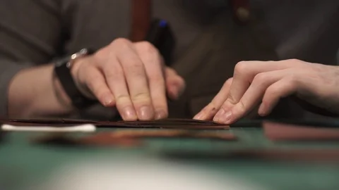 Tanner works in the workshop. Sitting at the table glues a purse of parts. Works Stock Footage 104925594