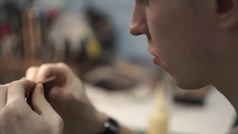 Tanner works in the workshop. Sitting at the table sticks together the details Stock Footage 104927376