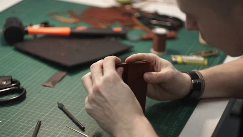 Tanner works in the workshop. Sitting at the table sticks together the details Stock Footage 104927385