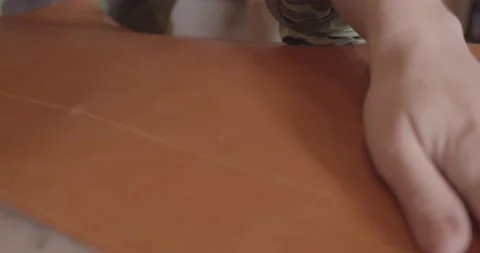 Tanner's hand on a sheet of leather. the master smoothes a piece of skin Stock Footage 163761676