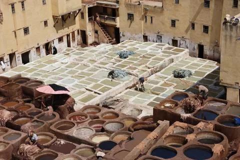Tannery workers process leather in dye pits Stock Photos