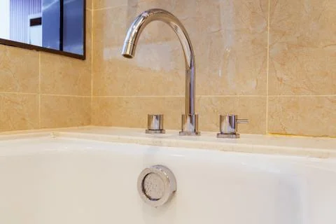 Tap and overflow button on bathroom Stock Photos
