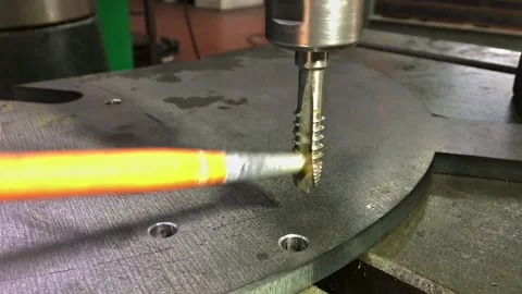 The tap cuts a thread in the hole. Professional tool for drilling and threading Stock Footage 172431581