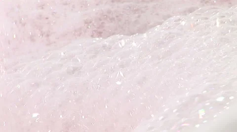 Tap pouring into bath as soap suds bubble Stock Footage