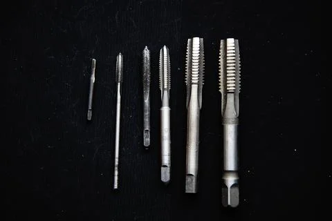 Tap for threading on details on a dark background. The tool. Stock Photos