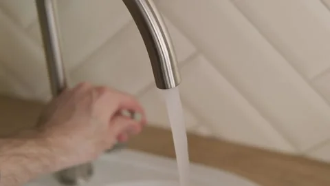 Tap water begin to flow from tap in kitchen in slow motion. Pure water Video stock 131305964