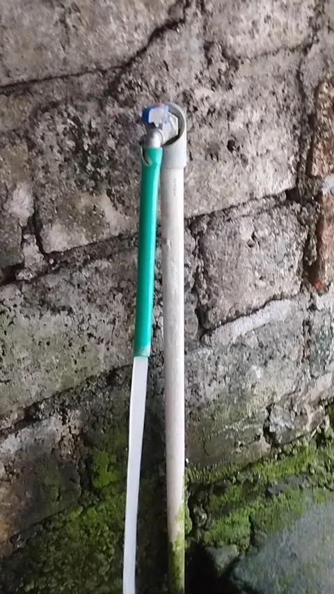 Tap water using a green hose flows profusely Stock Footage 225007328