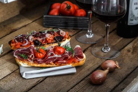 Tapas on crusty bread with red wine Stock Photos