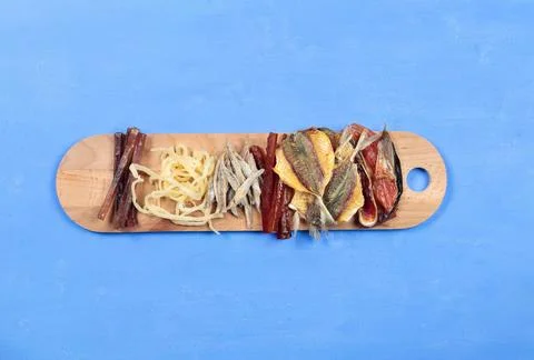Tapas, dried fish and squid for beer. A board with snacks. Top view on a blue Stock Photos