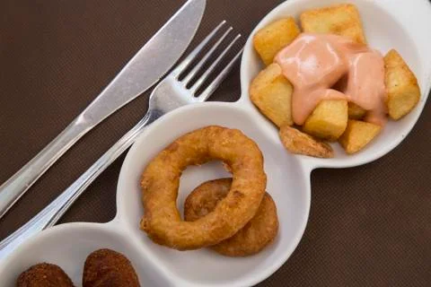 Tapas fried squid rings and potates braves Stock Photos