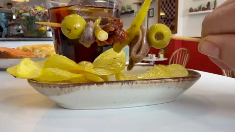 Tapas: Hand of a Man Taking a Spanish Tapa Skewer with Olives and Anchoives in Stock Footage 333550745
