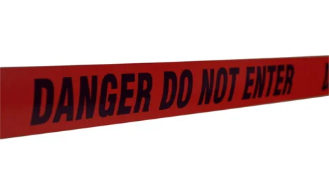 Tape barrier "danger, do not enter" in the wind on white screen.  Stock-Footage 57525869