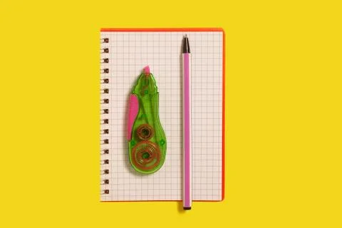 Tape corrector and pen lying on a notebook Stock Photos