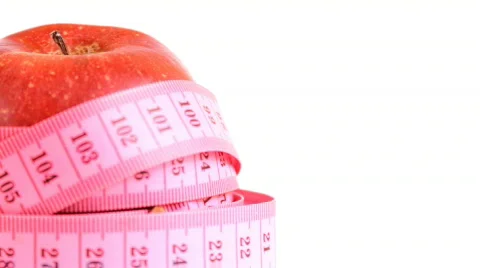 Tape measure wrapped around rotating red apple, loopable Stock Footage