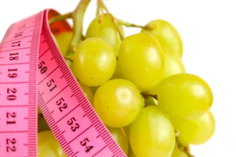 Tape measure wrapped around rotating grapes Stock Footage