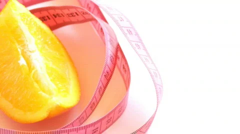 Tape measure wrapped around rotating orange, loopable Stock Footage