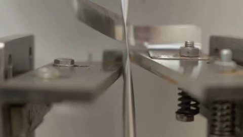 The tape of packages is divided into separate, cutting them with metal scissors Stock Footage 127777607