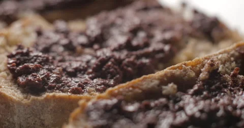 Tapenade olive puree on bread rotating close-up studio Stock Footage 280522967