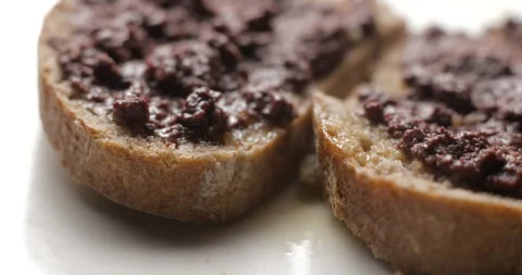 Tapenade olive puree on bread rotating close-up studio Stock-Footage 280523074