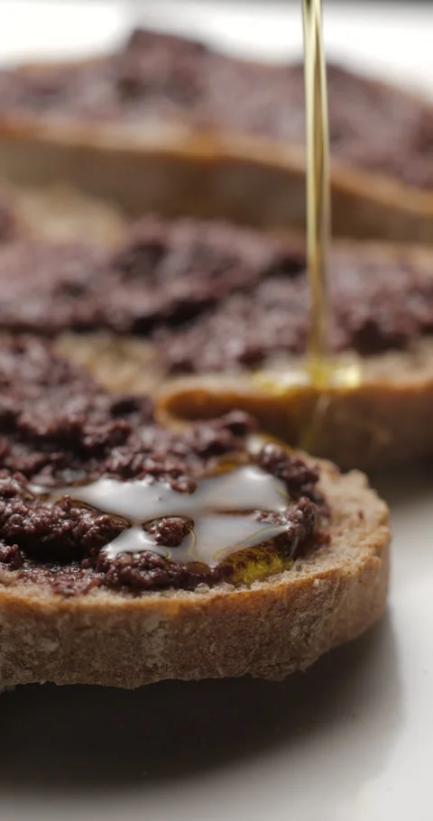 Tapenade olive puree on bread rotating close-up studio, vertical view 스톡 동영상 280523104