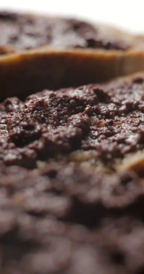 Tapenade olive puree on bread rotating close-up studio, vertical view Stock-Footage 280523177