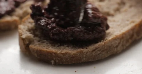 Tapenade olive puree on bread slow motion 스톡 동영상 280523181