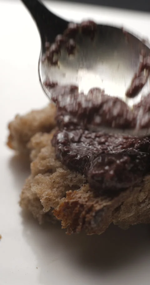 Tapenade olive puree on bread slow motion, vertical view Stock-Footage 280523209