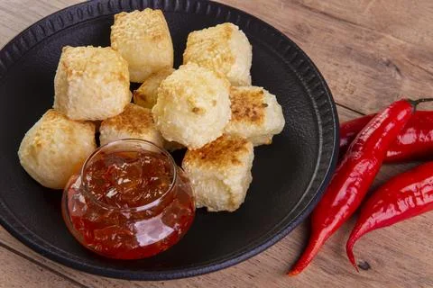 Tapioca dice served with pepper jelly. Wooden table Stock Photos