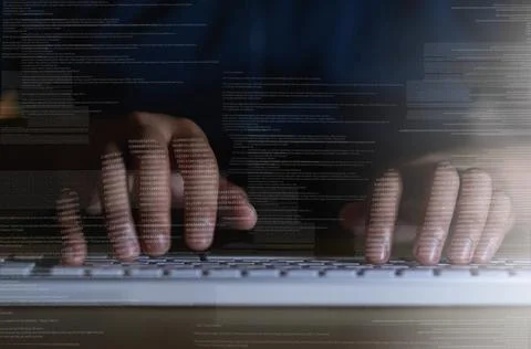 Tapping in to another network. Shot of an unrecognisable hacker using a computer Stock Photos