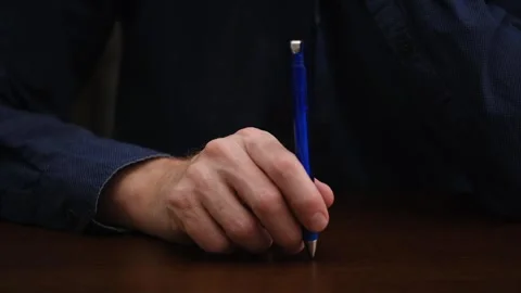 Tapping ballpoint pen on desktop close-up. man thoughtfully taps pen on table. Stock Footage 299084946
