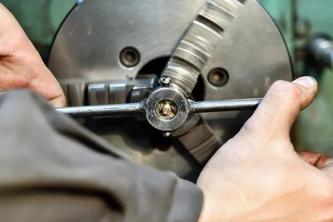 Tapping a bronze stud with a die on a lathe. Stock Photos