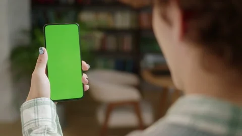 Tapping on Center Screen. Back View of Man at Home Office or Library Using Phone Stock Footage 171947071