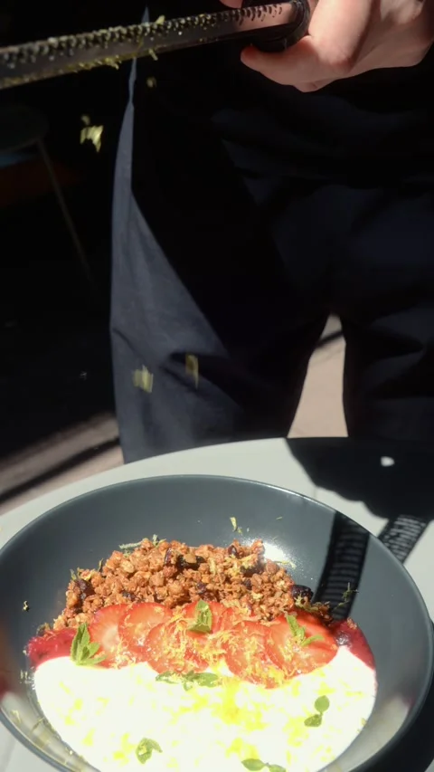 Tapping Grater with Lemon to Shake Fresh Zest into Bowl Stock Footage 339275562