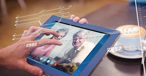 Tapping hand using tablet at cafe, showing seniors in pink top, yellow polo, Stock Photos