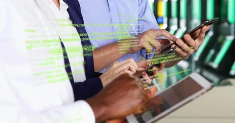 Tapping handheld devices, three IT specialists monitoring code in data center Stock Photos