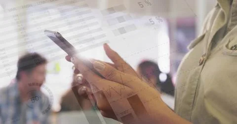 Tapping hands holding touchscreen at office, showing data charts overlay, beige Foto stock