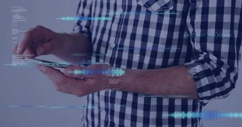 Tapping man in checked shirt rolled sleeves holding tablet in studio with blue 写真素材