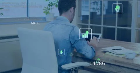 Tapping man wearing light blue denim shirt using tablet on office desk with d Stock Photos