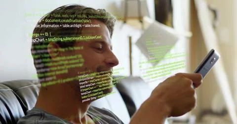 Tapping smartphone, adult man coding on dark couch in living room, with floating Foto stock