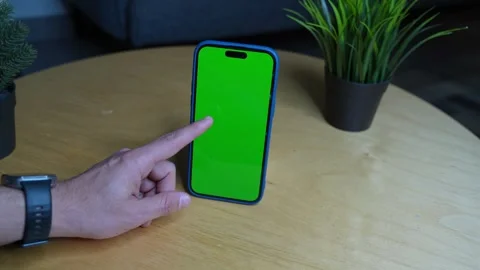 Tapping Smartphone with Green Screen – 4K Close-Up on Wooden Table. Stock-Footage 310039836