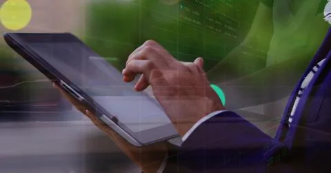 Tapping suited hands with white cuff and patterned tie, swiping tablet showing Stock Photos