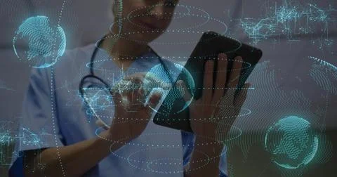 Tapping tablet clinician in light blue scrubs with stethoscope in clinic, Stock Photos