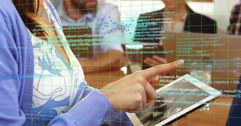 Tapping tablet developer wearing purple cardigan at workshop, with desks and Stockfoto's