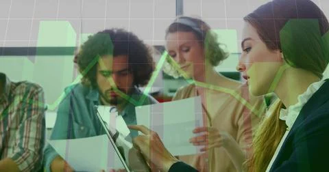 Tapping woman in blazer using tablet at meeting table, team reading papers under Stock Photos